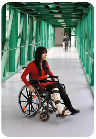 kobieta na wózku z nogą w gipsie
